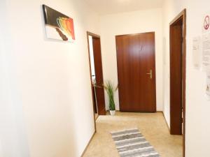 a hallway with a wooden door and a rug at SUNNYHOME Monteurwohnungen und Apartments in Schwandorf in Schwandorf in Bayern