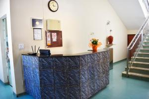 a lobby with a counter with a clock on the wall at Palace Hotel Itapira in Itapira