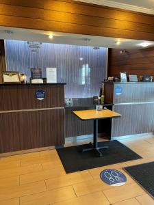 a counter with a table in the middle of a room at Baymont by Wyndham Chambersburg in Chambersburg