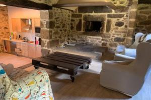 uma sala de estar com um sofá, uma mesa e cadeiras em Casa Rural en Valadouro Serra do Xistral Lugo En medio de la Naturaleza em Lagoa