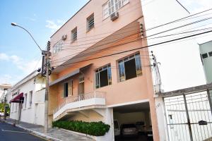 an orange and white building on a street at Palace Hotel Itapira in Itapira