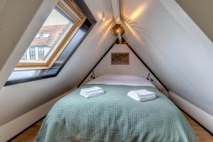 a small bedroom with a bed in the attic at B&B Larenstein logeren in een tiny house in Velp