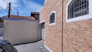 a brick building with a door and a garage at Casa Temporada Castelinho Campinas in Campinas