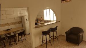 uma cozinha com um bar com bancos e um espelho em Casa Temporada Castelinho Campinas em Campinas