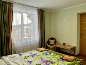 - une chambre avec un lit, une table et une fenêtre dans l'établissement UNDERHILLs house, à Yaremtche