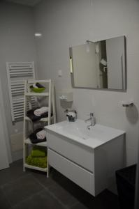 a bathroom with a sink and a mirror and towels at Cazenn Nazaré - Apartment Z in Nazaré