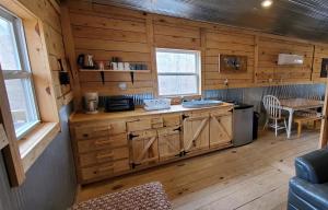 a kitchen with wooden cabinets and a table in a cabin at Stay In Current in Jadwin