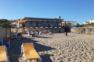 a beach with chairs and a building in the background at LA AGUADA - Villa de Mar in Villa Gesell +45 photos