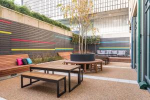 een patio met banken en een boom in een pot bij Astor College in Londen