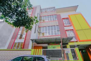 a building with a car parked in front of it at RedDoorz Syariah at Jalan Pramuka in Samarinda