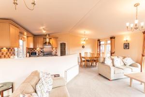 a living room with two couches and a kitchen at Saffron Lodge With Hot Tub in Malton