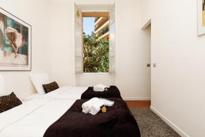 a white bedroom with two beds and a window at Villa Maiffret 1 YourHostHelper in Cannes