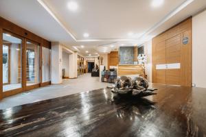 a living room with a wooden table and a hallway at Hotel Chalet Del Brenta in Madonna di Campiglio