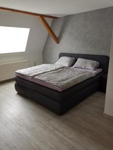 Bett in einem Zimmer mit Fenster in der Unterkunft Ferienwohnung Rote-Villa in Pobershau