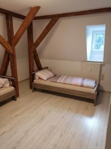 1 Schlafzimmer mit 2 Betten in einem Zimmer mit Holzbalken in der Unterkunft Ferienwohnung Rote-Villa in Pobershau