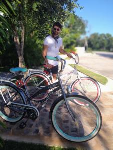 a man standing next to a bike on a street at Panther Bay Villa & Golf in Akumal