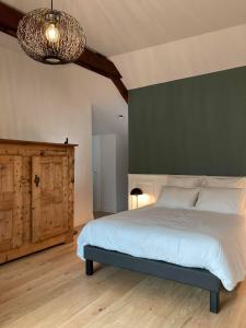 - une chambre avec un grand lit et un mur vert dans l'établissement Domaine Jacqueline Père & Filles, à Aix-les-Bains