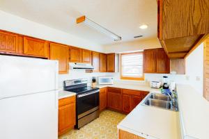 a kitchen with wooden cabinets and a white refrigerator at Harper House #4BB in Buxton