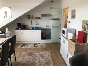a kitchen with white cabinets and a table and a counter at Ferienwohnung Bergisch Gladbach in Bergisch Gladbach