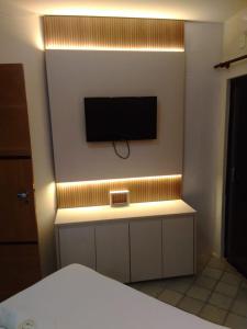 a bedroom with a tv on the wall at Píer Sul Apart Hotel - Circuito do carnaval in Salvador