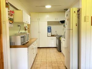 a kitchen with white cabinets and white appliances at Paine - Hermosa Parcela de Agrado in Santiago