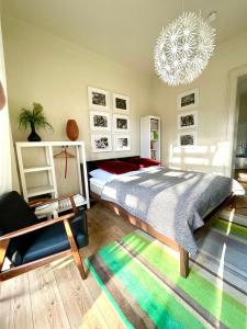 - une chambre avec un grand lit et un lustre dans l'établissement JETHON Studio-Appartement im Grünen, à Bernburg