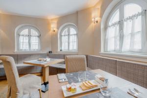 restauracja z dwoma stołami, krzesłami i oknami w obiekcie Hotel Chalet Del Brenta w Madonna di Campiglio
