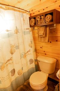 a bathroom with a toilet and a shower curtain at Crescent Beach and RV Park in Port Angeles