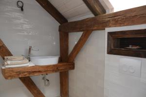 uma casa de banho com um lavatório numa prateleira de madeira em Penzion Okamžik Stanovice em Nová Cerekev