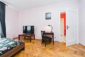 una camera con letto, scrivania e TV di Modern Urban Escape - Old Town Apartment a Cracovia