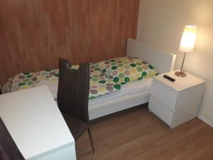 um pequeno quarto com uma cama e uma mesa de cabeceira em City Boardinghouse Alsdorf em Alsdorf