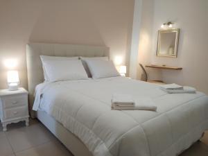 a bedroom with a white bed with two towels on it at Stylish home - comfortable holidays near the beach. in Panormos Rethymno