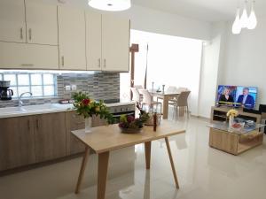 a kitchen with white cabinets and a table with flowers on it at Stylish home - comfortable holidays near the beach. in Panormos Rethymno