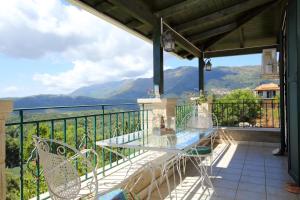 a balcony with a table and chairs and mountains at Casa Serenata in Pinakokhórion