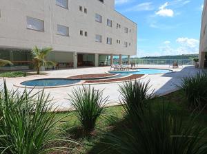 a building with two swimming pools in front of it at Hotel Manacá in Sacramento