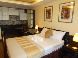a bedroom with a large bed in a room at Silver Oaks Suites & Hotel in Manila