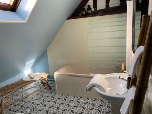 uma casa de banho com uma banheira e um lavatório em La maison de Cruso em Sens
