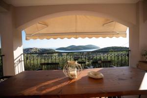 a dining room table with a view of a balcony at Great View villa in Sivota