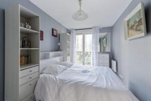 um quarto com uma cama branca e uma janela em Large and calm 3br in La Plaine St-Denis at the doors of Paris - Welkeys em Saint-Denis