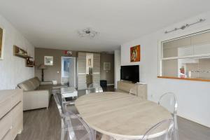 uma sala de jantar e sala de estar com mesa e cadeiras em Large and calm 3br in La Plaine St-Denis at the doors of Paris - Welkeys em Saint-Denis