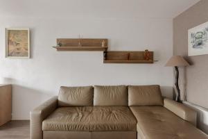 uma sala de estar com um sofá castanho num quarto em Large and calm 3br in La Plaine St-Denis at the doors of Paris - Welkeys em Saint-Denis