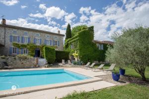 a swimming pool in front of a house at MAISON BEAUMONT in Le Verdier
