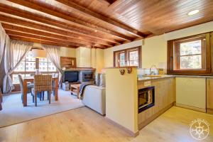 a kitchen and living room with wooden ceilings and a table at PEULHA de Alma de Nieve in Baqueira-Beret