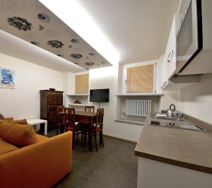 una cucina e un soggiorno con divano e tavolo di Apartements Coeur de Ville ad Aosta