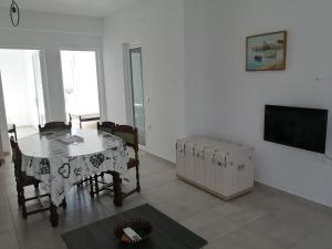 a dining room with a table and a television at Almira Ghouse in Almiropotamos