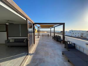 balkon ze stołem i ławkami w budynku w obiekcie Casa Sunshine Cotillo Mar w mieście Cotillo