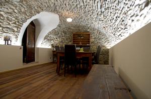 uma sala de jantar com uma mesa e uma parede de pedra em Apartements Coeur de Ville em Aosta