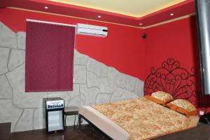 een slaapkamer met een bed en een rode muur bij Princ Plaza Hotel in Jerevan