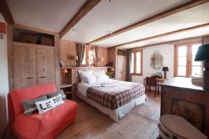 um quarto com uma cama e uma cadeira vermelha em Chalet Bizet - A touch of Parisian design in the Alps em Montriond