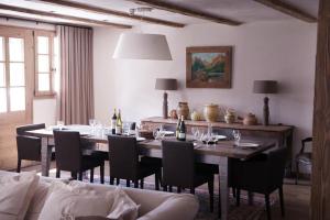 uma sala de jantar com uma mesa com cadeiras e garrafas de vinho em Chalet Bizet - A touch of Parisian design in the Alps em Montriond